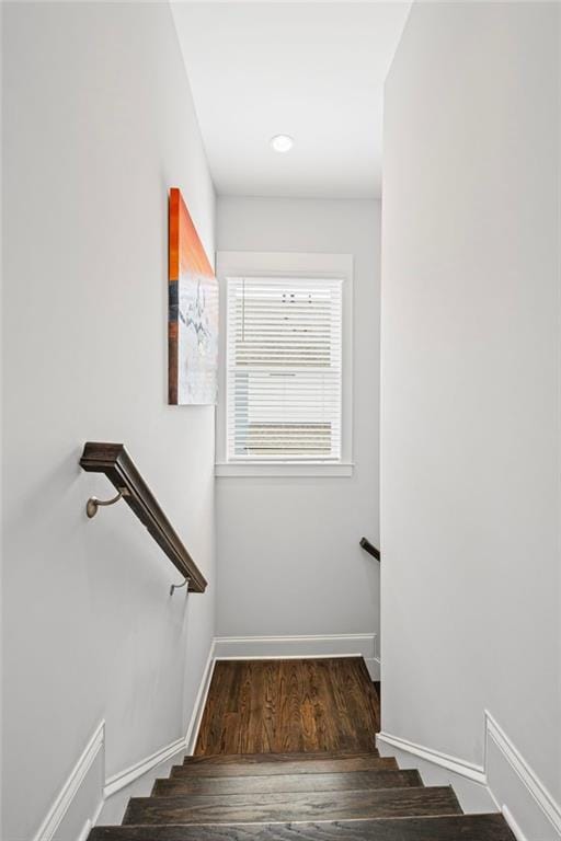 stairway featuring baseboards and wood finished floors