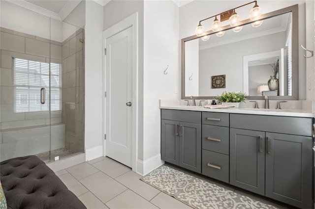 full bath featuring tile patterned flooring, double vanity, baseboards, a sink, and a stall shower