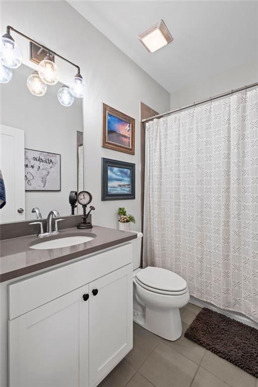 full bath featuring vanity, tile patterned floors, and toilet