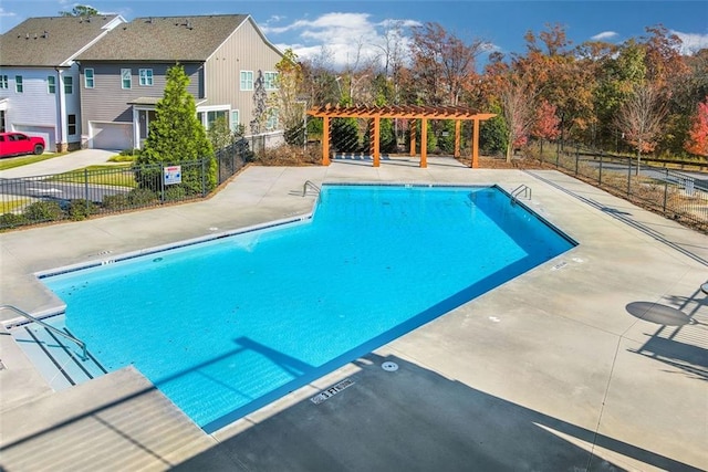 pool with a pergola, fence, and a patio