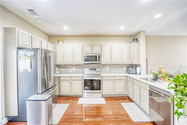 3068 Cedar Glade Ln, Buford, GA 30519 - kitchen featuring sink, light hardwood / wood-style flooring, stainless steel appliances, white cabinets, and decorative backsplash