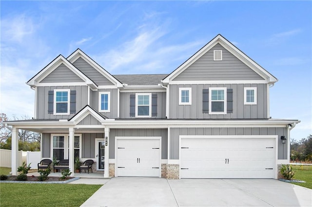 craftsman inspired home with a porch, a garage, and a front lawn