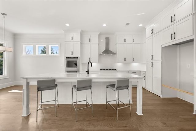 1005 Coleman Place Dr, Roswell, GA 30075 - kitchen featuring wall chimney range hood, white cabinetry, light countertops, wood finished floors, and a kitchen breakfast bar