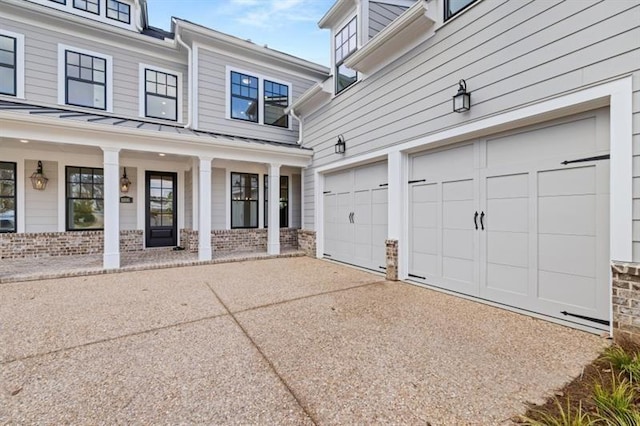 1005 Coleman Place Dr, Roswell, GA 30075 - view of home's exterior featuring a standing seam roof, driveway, covered porch, a garage, and a metal roof