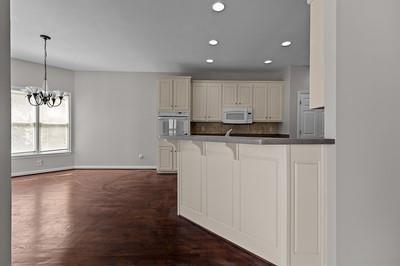 kitchen with white appliances, kitchen peninsula, a notable chandelier, hanging light fixtures, and a kitchen bar