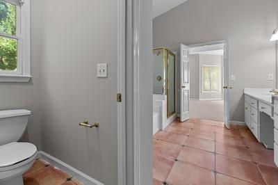 bathroom featuring a shower with door, tile patterned floors, vanity, and toilet