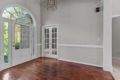 entryway featuring french doors, a chandelier, and dark hardwood / wood-style flooring