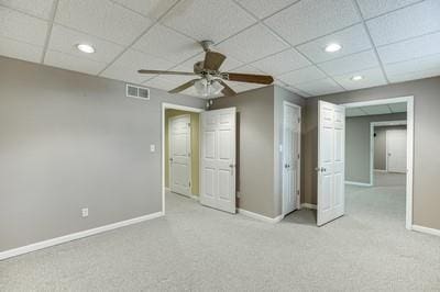 unfurnished bedroom featuring ceiling fan, light colored carpet, and a drop ceiling