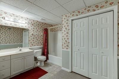 full bathroom with vanity, a drop ceiling, toilet, and shower / tub combo with curtain