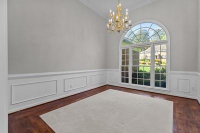 unfurnished room featuring crown molding, a chandelier, and dark hardwood / wood-style flooring