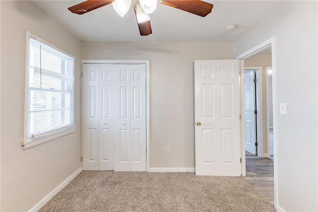 unfurnished bedroom with ceiling fan, a closet, carpet, and baseboards