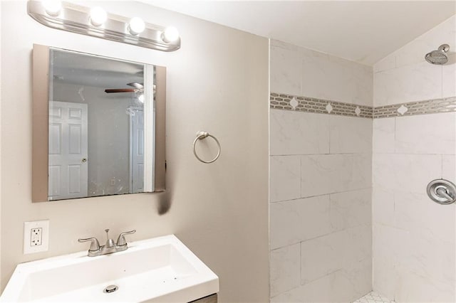 bathroom with a ceiling fan, a tile shower, and vanity