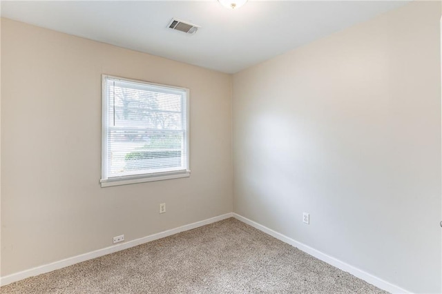 empty room with baseboards, visible vents, and light colored carpet