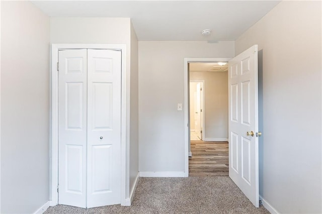 unfurnished bedroom featuring a closet, carpet flooring, and baseboards