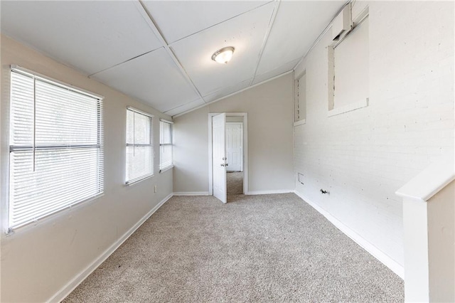 unfurnished room with lofted ceiling, light colored carpet, and baseboards