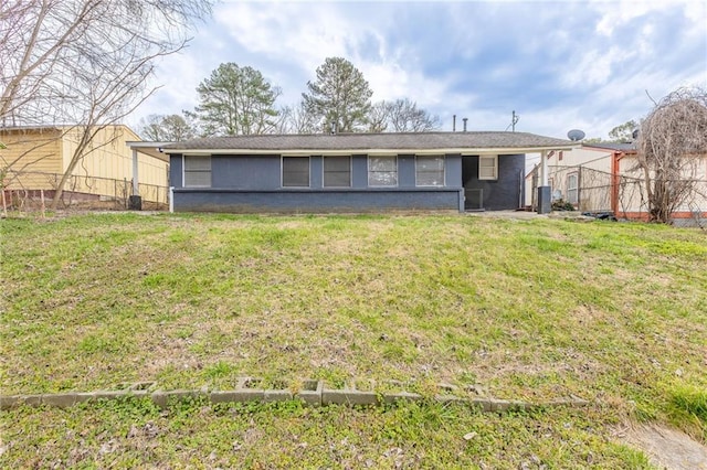 rear view of house featuring a lawn and central AC unit