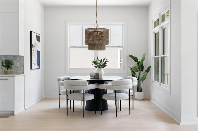 dining room featuring a healthy amount of sunlight and light hardwood / wood-style flooring