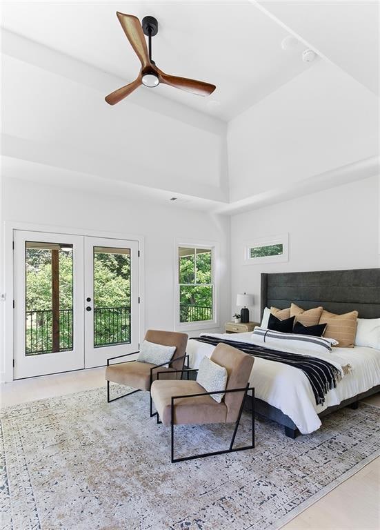 bedroom with access to exterior, french doors, ceiling fan, and a towering ceiling