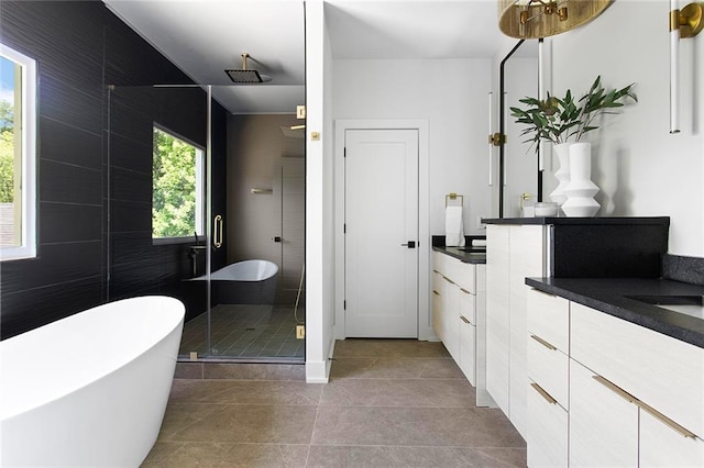 bathroom with tile patterned flooring, plus walk in shower, and vanity