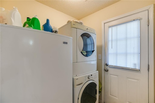 washroom with stacked washer and clothes dryer, a textured ceiling, and laundry area