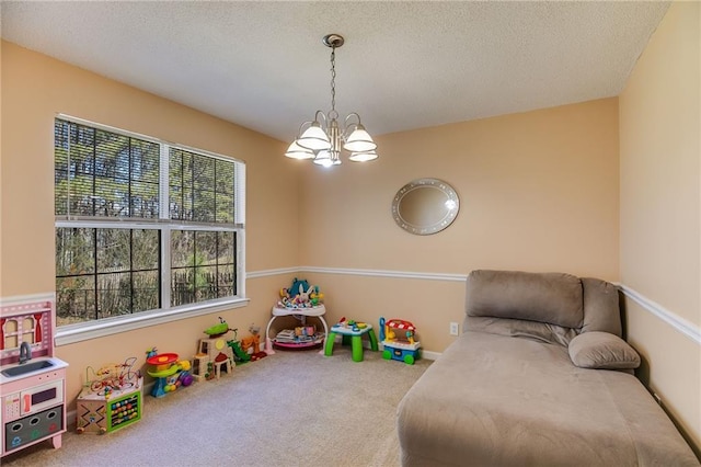 rec room with a textured ceiling, carpet, and an inviting chandelier