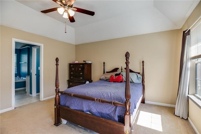 bedroom with light carpet, baseboards, ensuite bathroom, and lofted ceiling