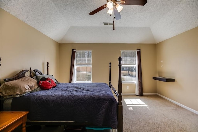 carpeted bedroom featuring a ceiling fan, lofted ceiling, visible vents, and baseboards