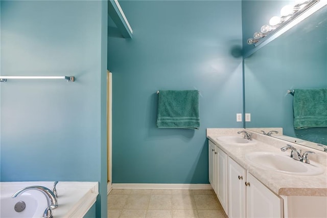 bathroom with double vanity, a sink, a bathtub, and baseboards