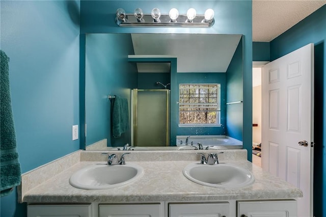 bathroom featuring a garden tub, double vanity, a sink, and a shower stall