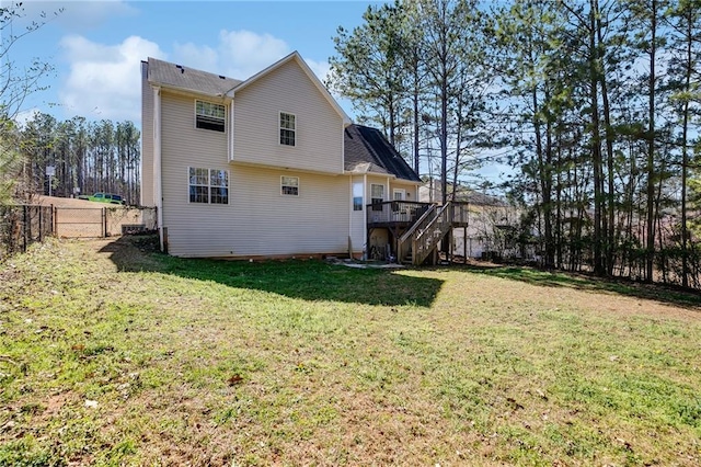 rear view of house featuring a deck, a yard, stairway, and a fenced backyard