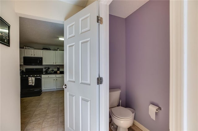 bathroom featuring baseboards and toilet