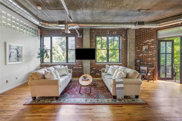 3235 Roswell Rd NE Unit 505, Atlanta, GA 30305 - living area featuring brick wall, plenty of natural light, wood finished floors, and baseboards