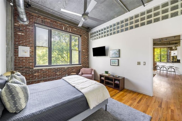3235 Roswell Rd NE Unit 505, Atlanta, GA 30305 - bedroom featuring brick wall, wood finished floors, ceiling fan, and baseboards