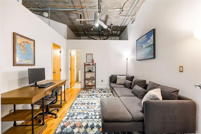 3235 Roswell Rd NE Unit 505, Atlanta, GA 30305 - living room with wood finished floors, an office area, a high ceiling, and baseboards