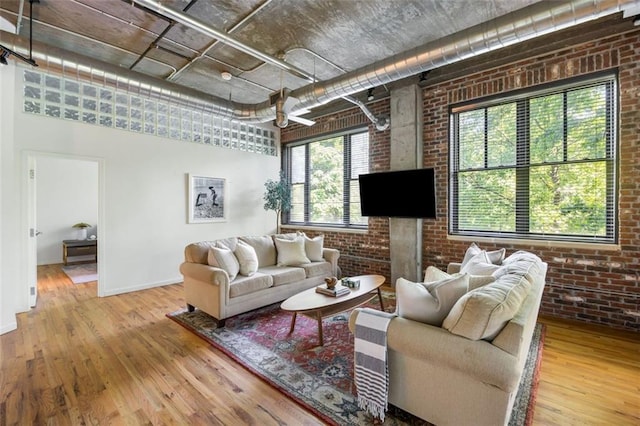 3235 Roswell Rd NE Unit 505, Atlanta, GA 30305 - living room with brick wall, wood finished floors, and baseboards
