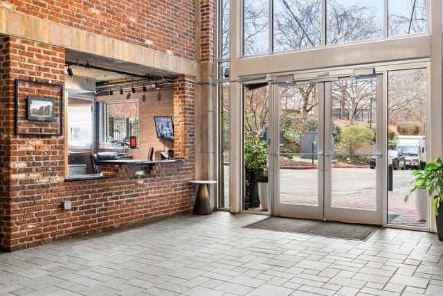 3235 Roswell Rd NE Unit 505, Atlanta, GA 30305 - doorway featuring a towering ceiling, healthy amount of natural light, and brick wall