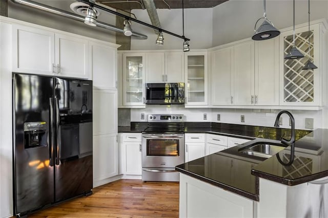 3235 Roswell Rd NE Unit 505, Atlanta, GA 30305 - kitchen with stainless steel appliances, a sink, white cabinetry, dark countertops, and a peninsula
