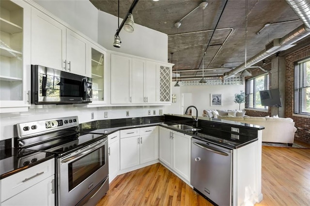 3235 Roswell Rd NE Unit 505, Atlanta, GA 30305 - kitchen with appliances with stainless steel finishes, a sink, open floor plan, light wood-style floors, and white cabinetry