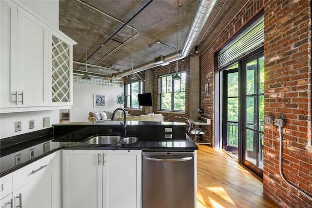 3235 Roswell Rd NE Unit 505, Atlanta, GA 30305 - kitchen featuring dishwasher, a sink, brick wall, light wood-style floors, and open floor plan