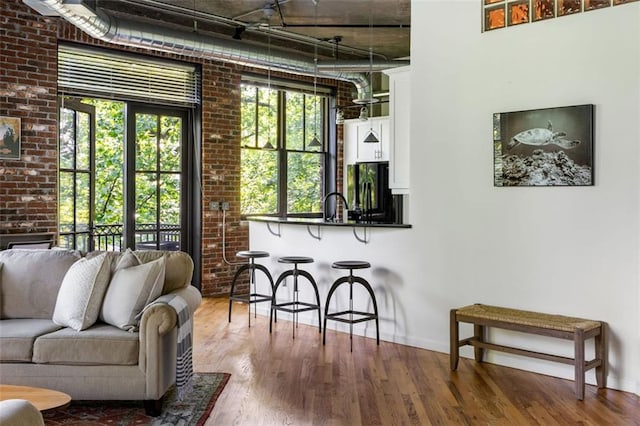 3235 Roswell Rd NE Unit 505, Atlanta, GA 30305 - living room with wood finished floors, healthy amount of natural light, baseboards, and brick wall