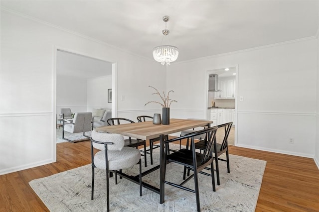 dining room featuring hardwood / wood-style floors, a notable chandelier, and ornamental molding