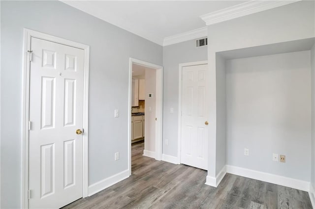 unfurnished bedroom with crown molding and light hardwood / wood-style flooring