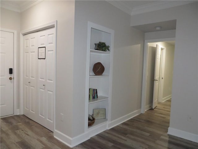 hall with dark hardwood / wood-style flooring, built in features, and ornamental molding