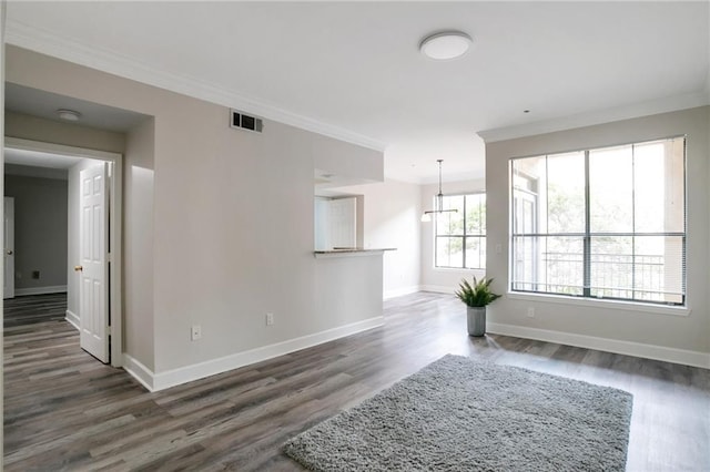 unfurnished living room featuring dark hardwood / wood-style floors and ornamental molding