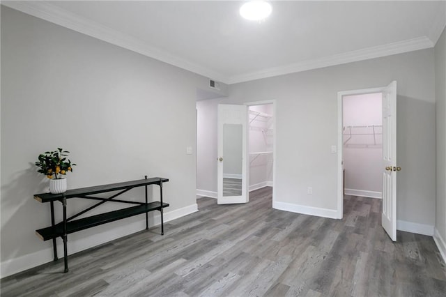 unfurnished room with hardwood / wood-style floors and crown molding