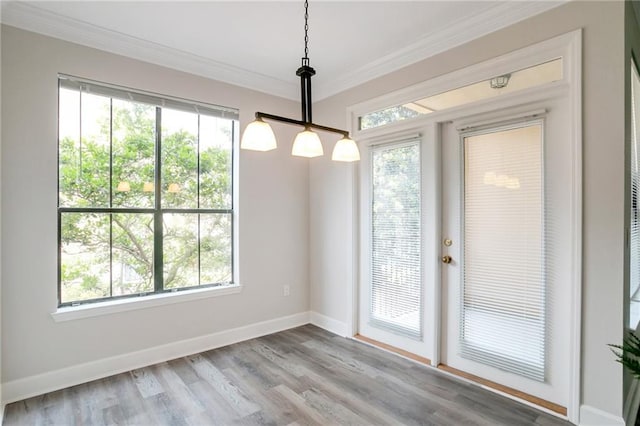 unfurnished dining area featuring light hardwood / wood-style floors and crown molding