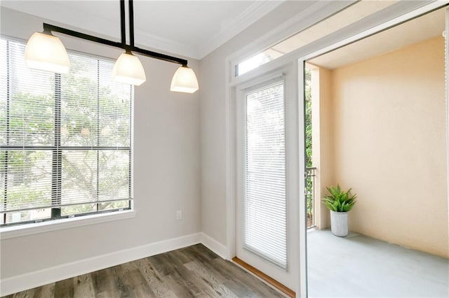 unfurnished dining area featuring ornamental molding and dark wood-type flooring