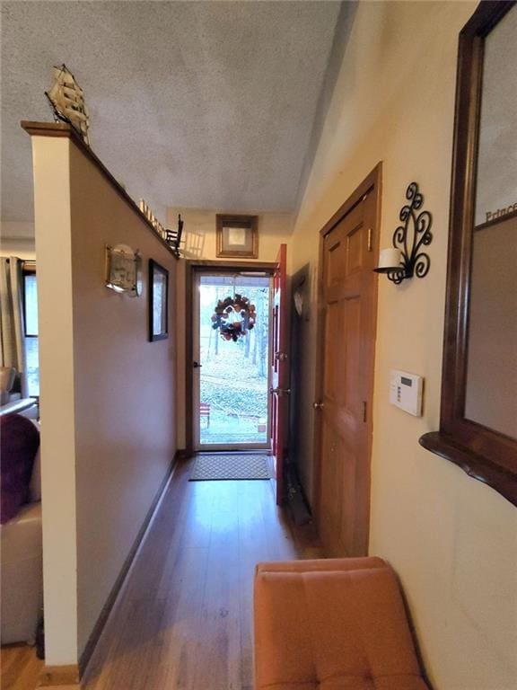 doorway with hardwood / wood-style floors and a textured ceiling