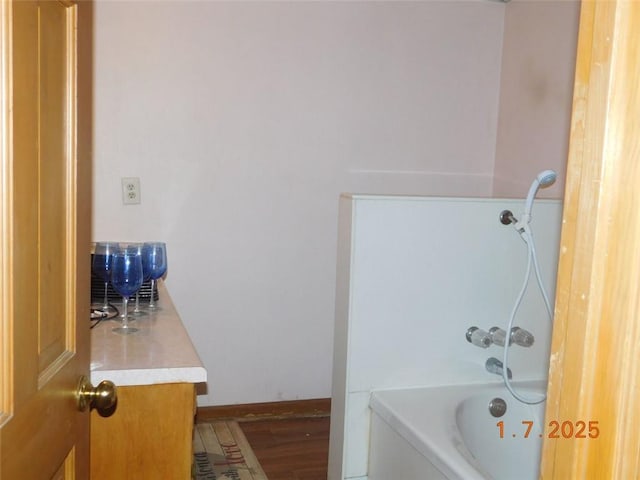 bathroom with hardwood / wood-style flooring, vanity, and shower / bathing tub combination