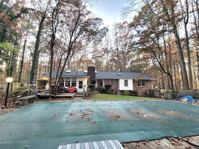 back of house featuring a swimming pool side deck